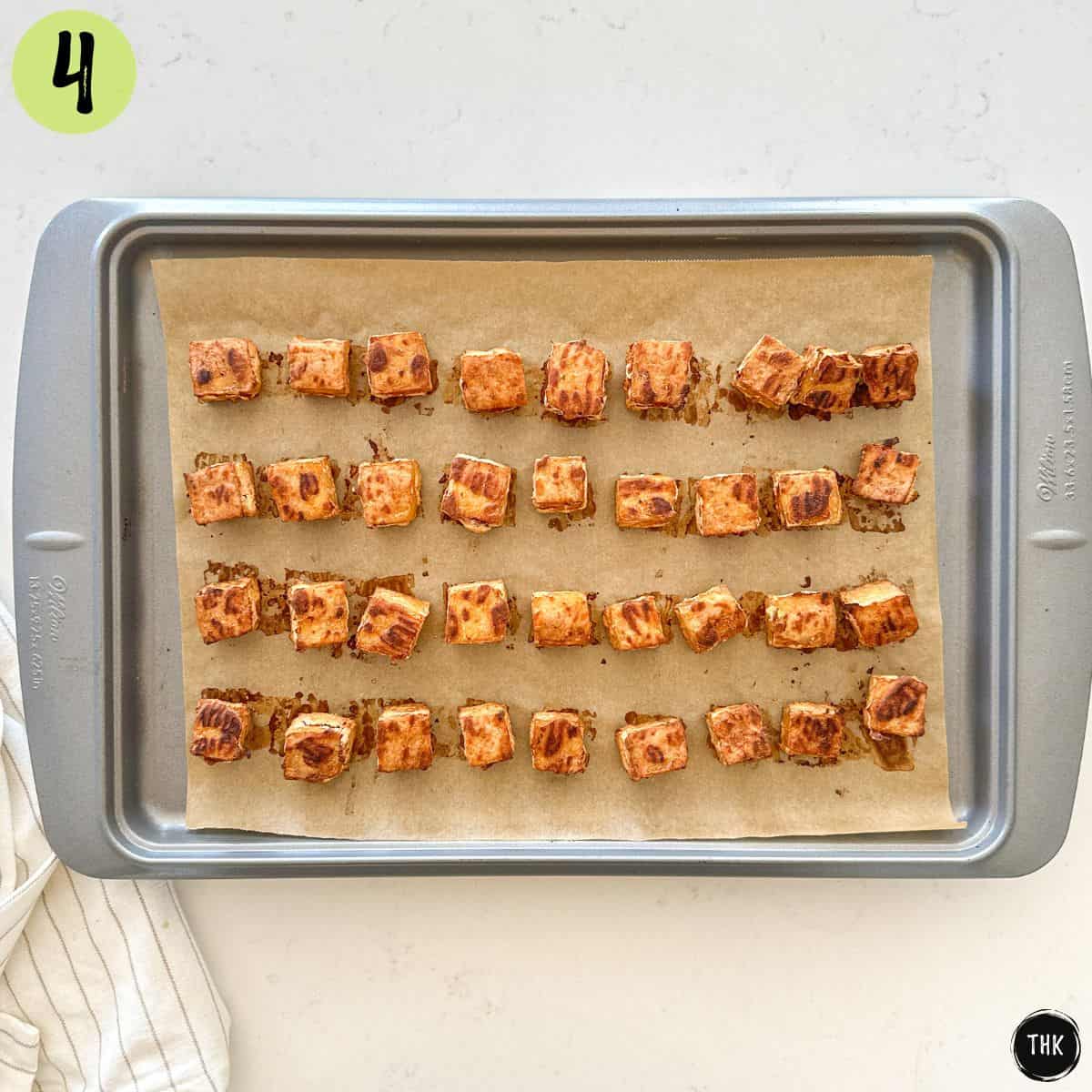Crispy baked tofu cubes on a baking tray.
