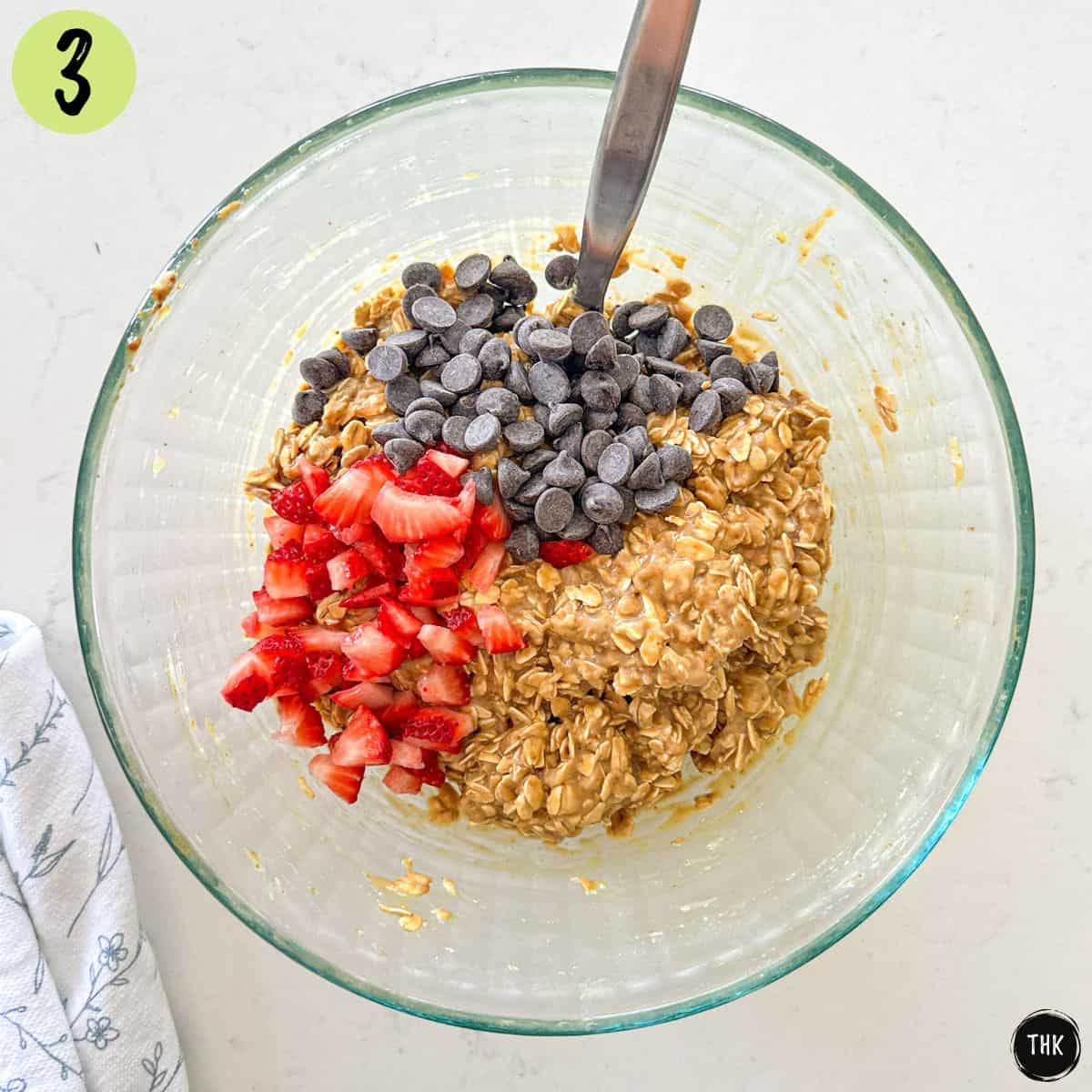 Oatmeal cookie batter with chopped strawberries and chocolate chips on top.