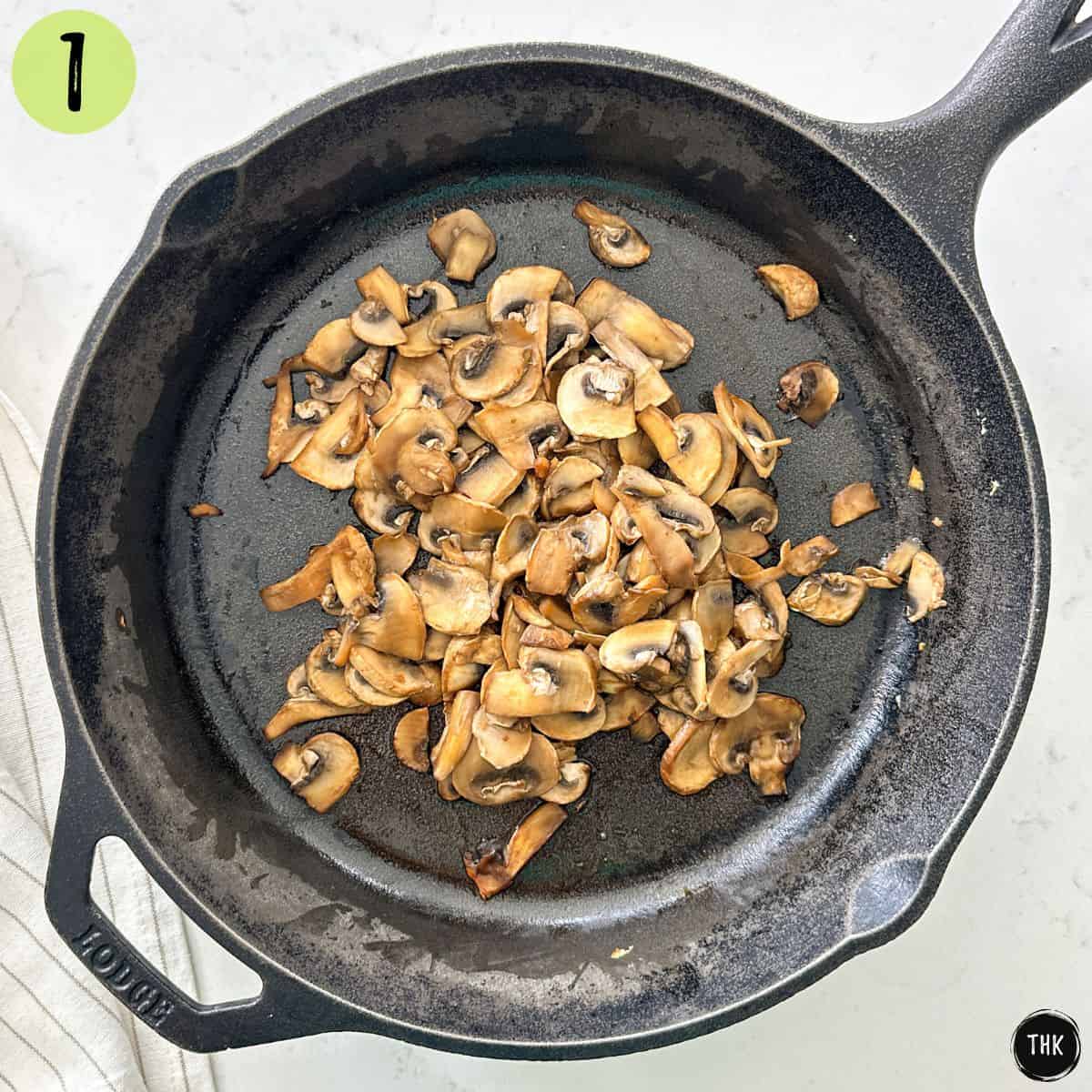 Sauteed mushrooms inside cast iron pan.