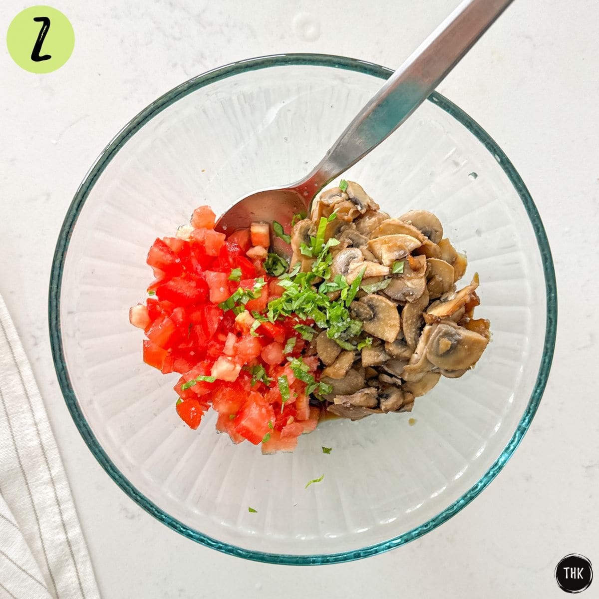 Mixing bowl with sauteed mushrooms, tomatoes, basil, and spices.