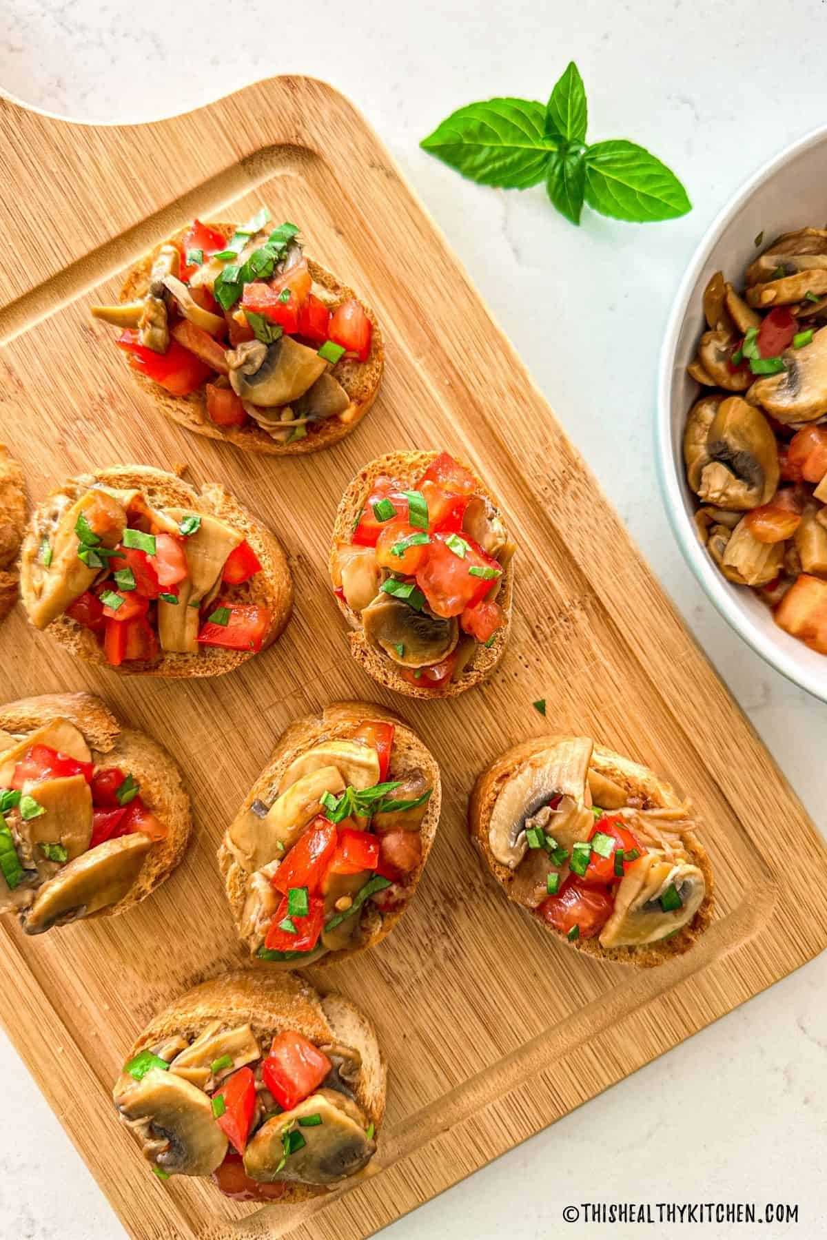 Bruschetta ai funghi on wooden cutting board.