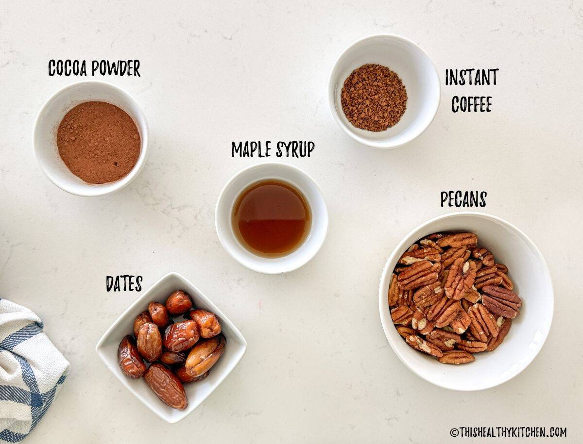 Bowls of instant coffee, cocoa powder, maple syrup, pecans and dates.