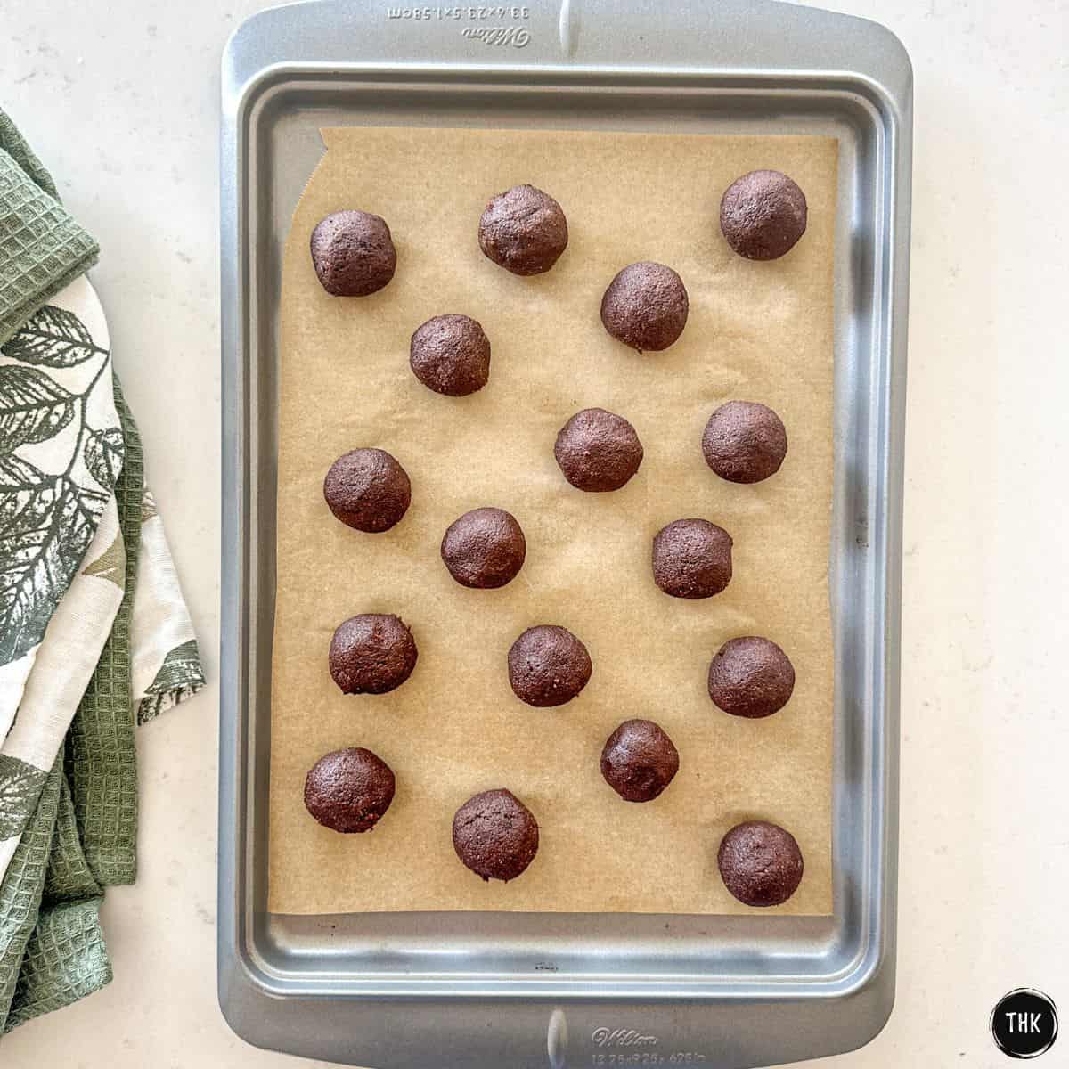 Chocolate pumpkin protein balls on baking sheet.