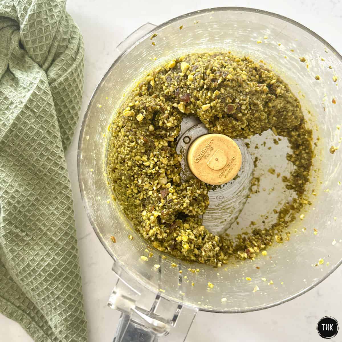 Green nut mixture inside food processor bowl.