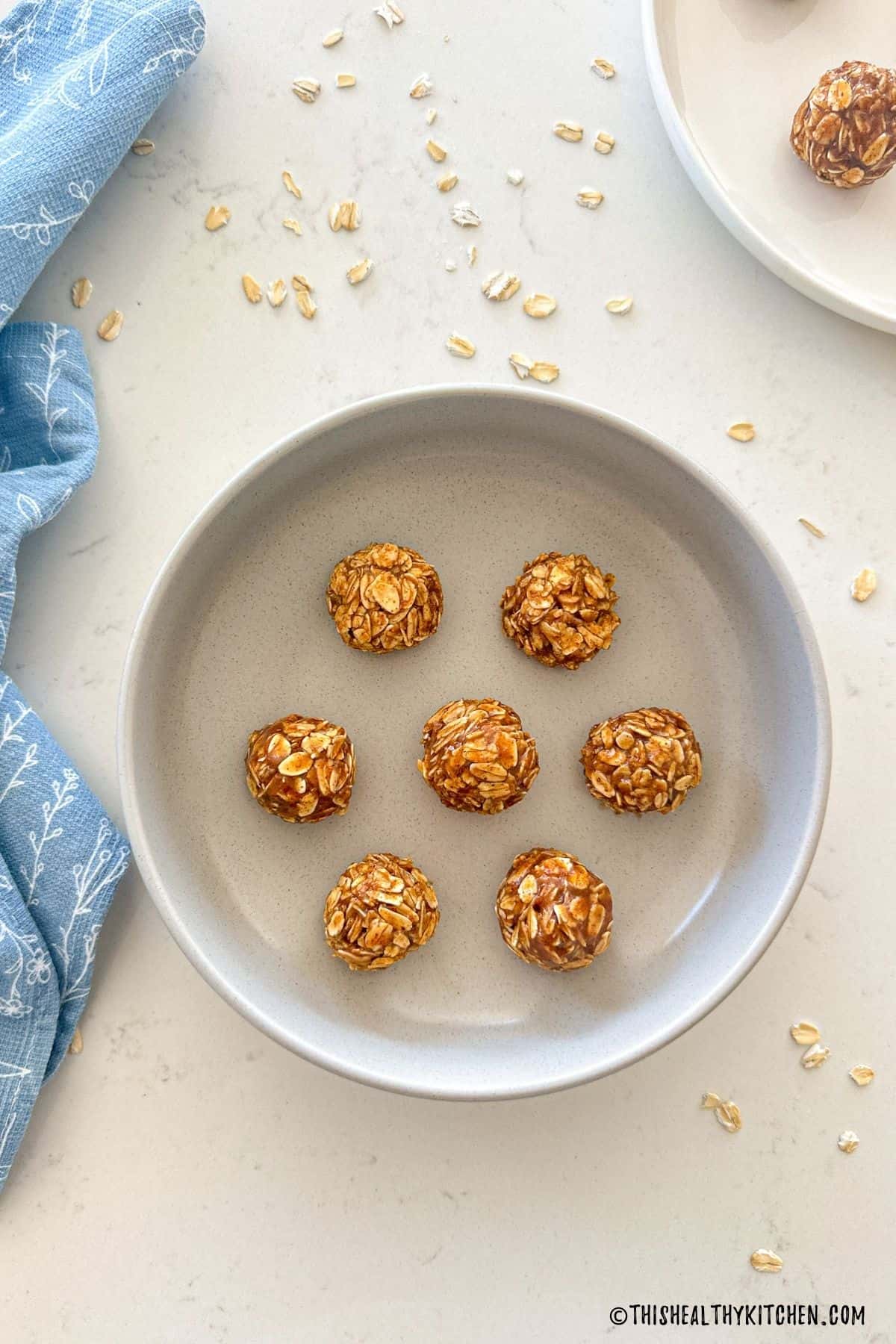 Oatmeal bliss balls in bowl with oats surrounding it.