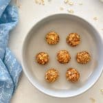 Oatmeal bliss balls in bowl with oats surrounding it.